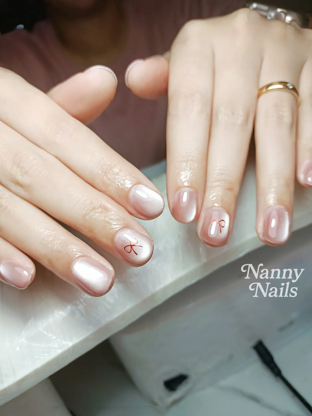 สีลูกแก้วเล่นแสงสวย ๆ + โบว์แดง ลายเล็บมือ นู้ด พีช รหัส A207 ร้านทำเล็บนครพนม Nanny Nails