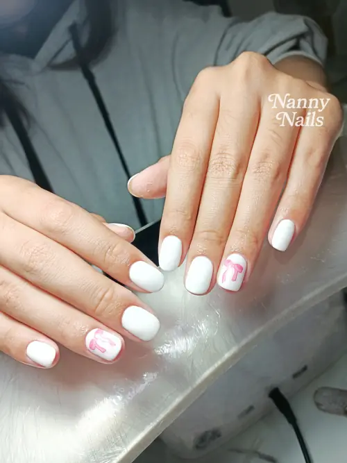 เล็บสีขาวมินิมอล ประดับโบว์ชมพูหวานๆ รูปที่ 1 รหัส A107 ร้านทำเล็บนครพนม