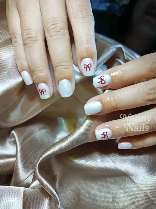 เล็บขาวมุก เติมความน่ารักด้วยโบว์สีแดง รหัส A50